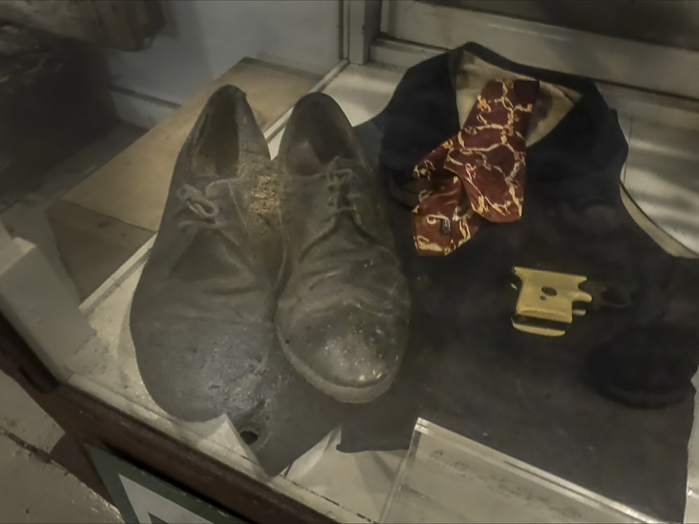 pair of old black men's shoes, pistol and clothing