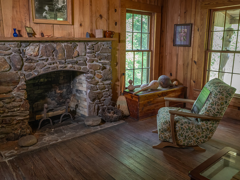 chair in front of fireplace in wood paneled room