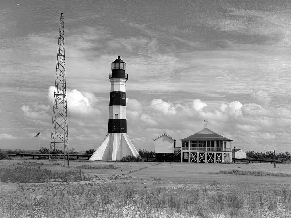 radio tower next to black and white lighthouse next to building in black and white photo