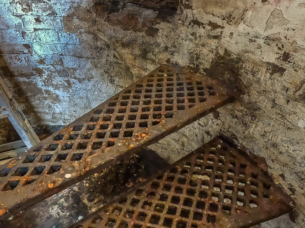 rusted iron steps in brick wall