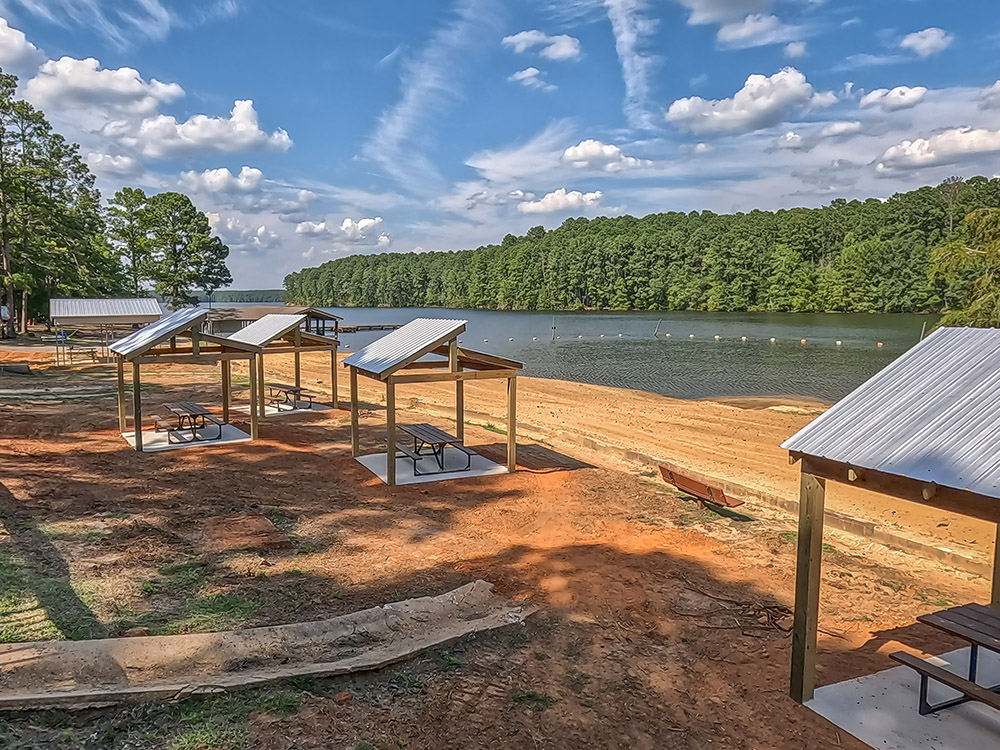 reddish sand beach on lake with cabanas and swimming area