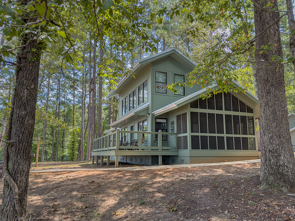 2 story green wooden cabin in forest