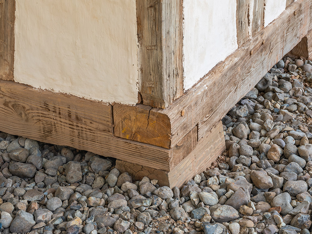 wood frame and white bousillage exterior wall on gravel