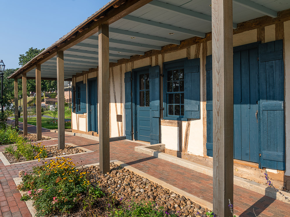 front porch of wood and mud constructed Creole house on sunny day