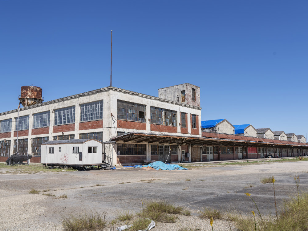 exterior of two story brick and concrete Ford assembly plant under blue sky