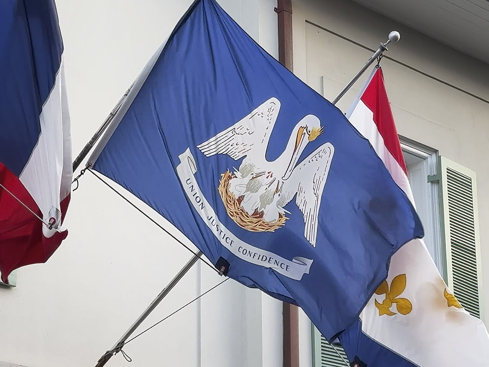 the blue Louisiana state flag showing a white pelican and the motto union justice confidence