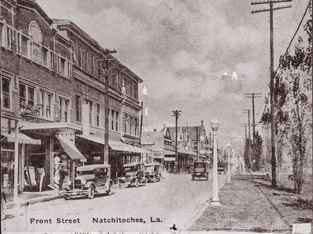 old bkack and white picture of buildings with model T cars.