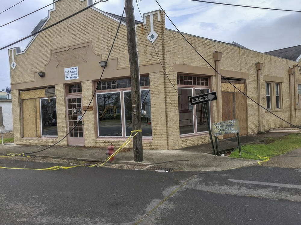 damaged tan brick building with yellow caution tape