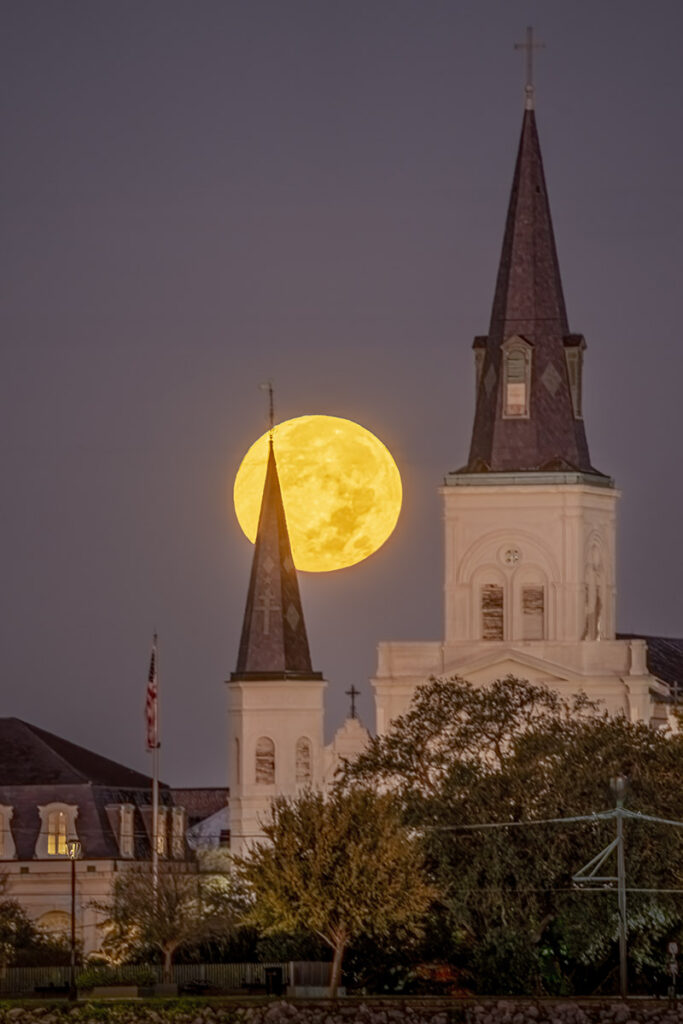 full moon behind the spire of St. Louis Cathedral