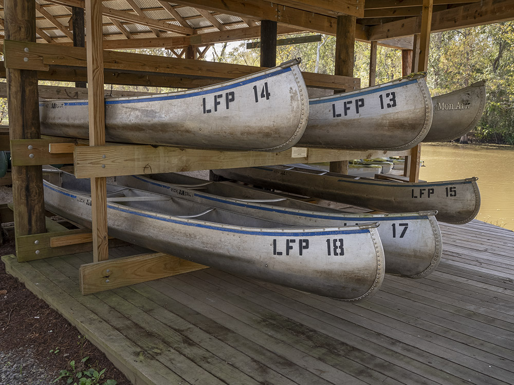 rental canoes stacked under a roof at Lake Fausse Pointe State Park