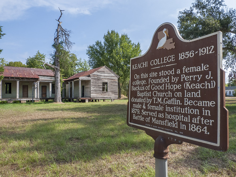 old wooden building with historical marker for Keachi College