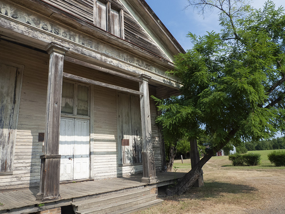 porch and storefront of old wood building near tree