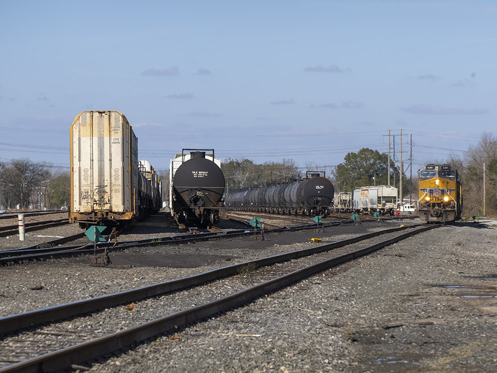 railroad tracks rail cars and engine under blue sky