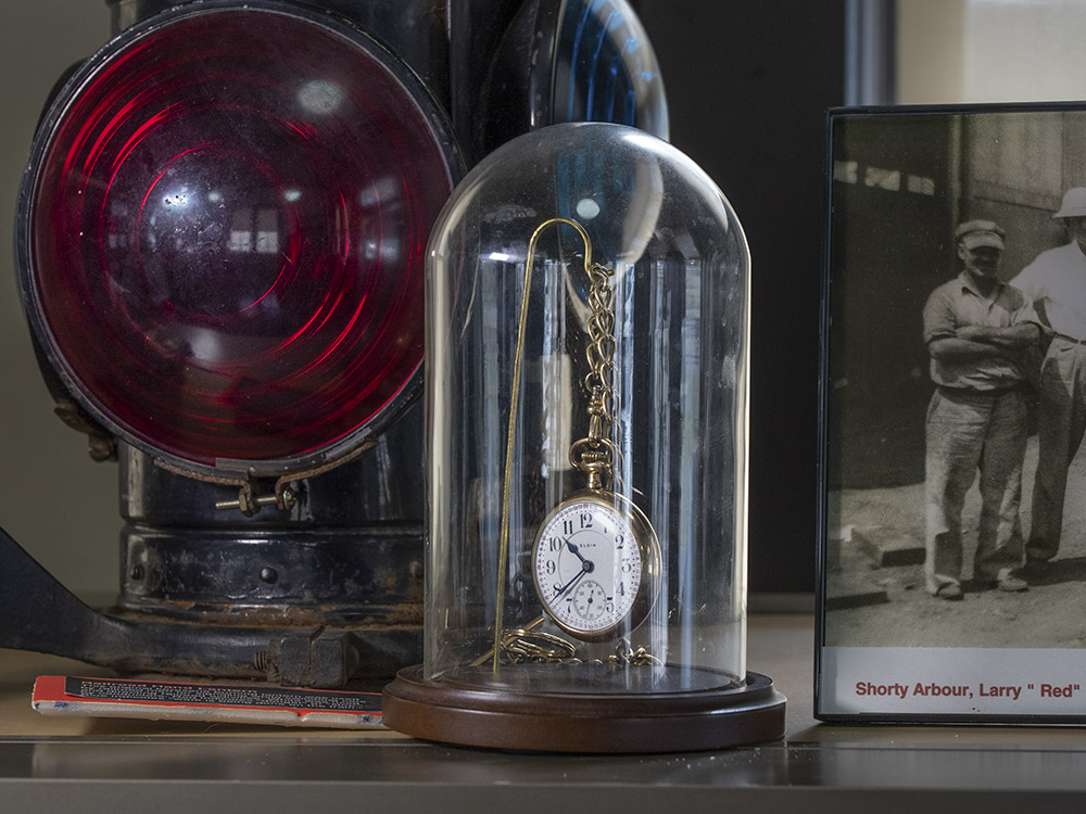 gold pocket watch in museum display case among train artifacts