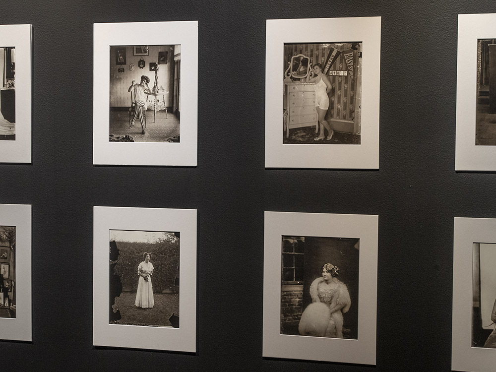 museum wall display of several black & white photos of women