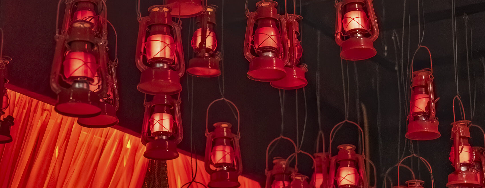 numerous red lanterns handing from ceiling