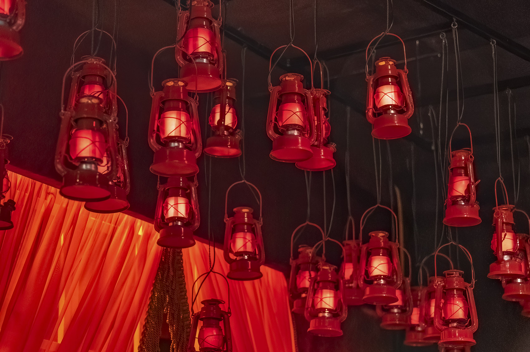 numerous red lanterns handing from ceiling