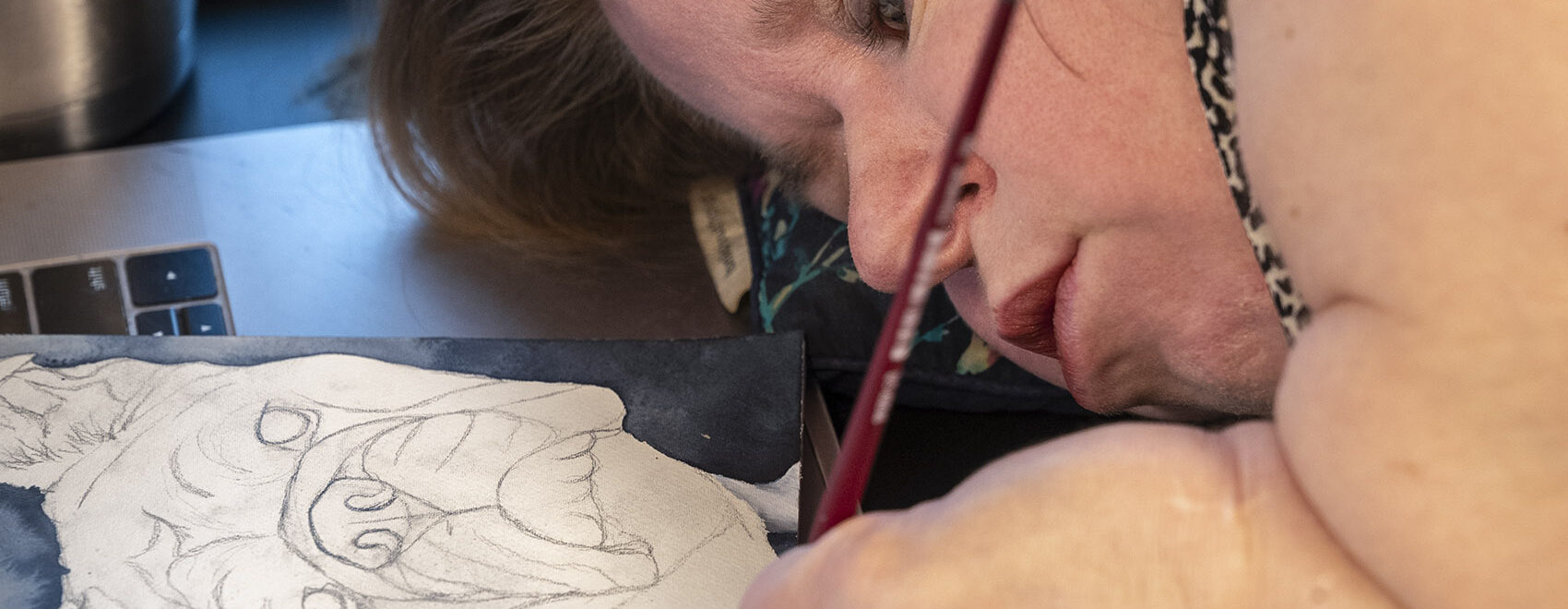 woman watercolor artist paints lying down