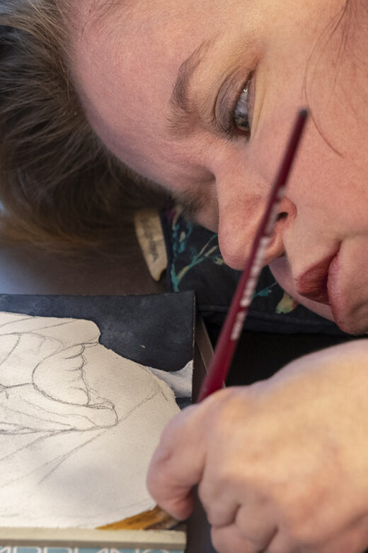 woman watercolor artist paints lying down