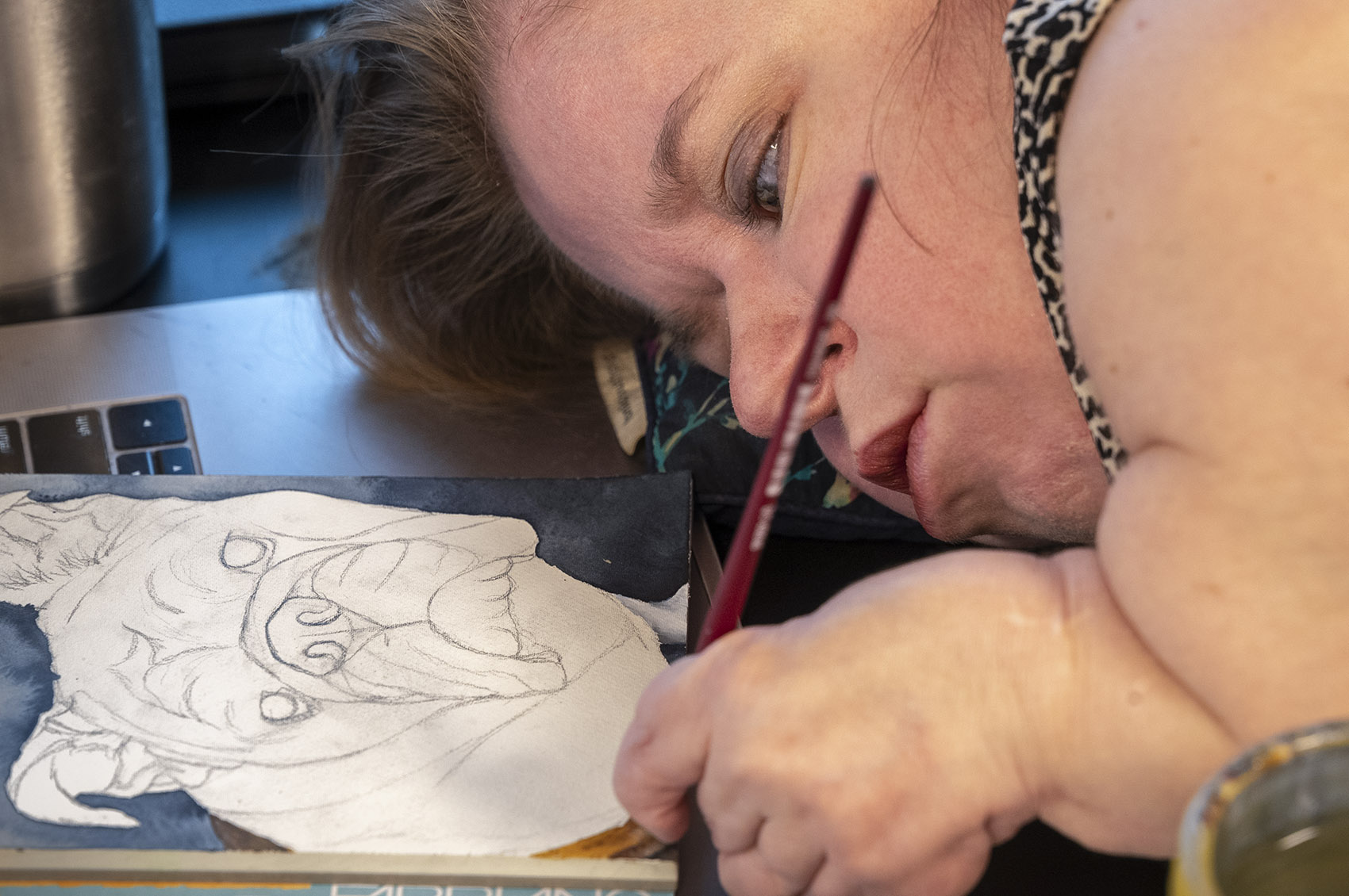woman watercolor artist paints lying down