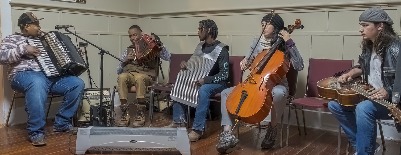 musicians play in jam session on accordion, rub board and cello.