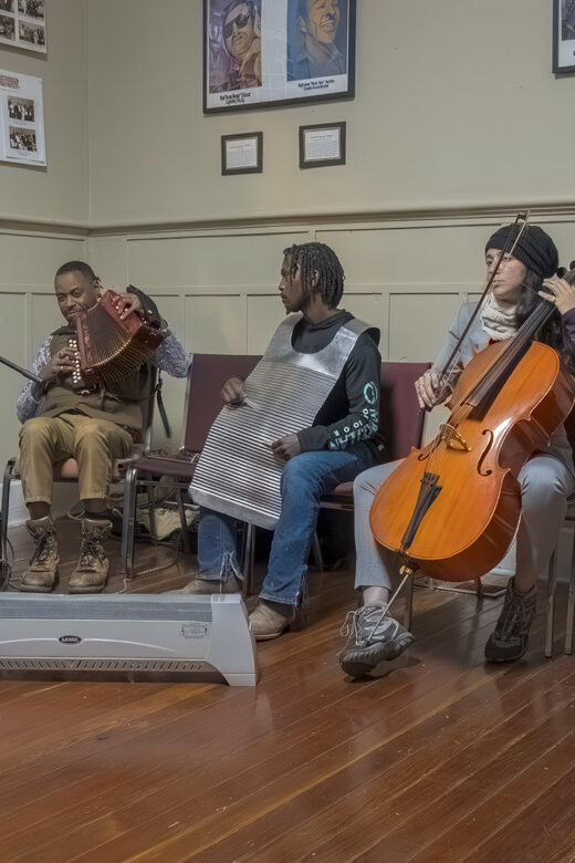 musicians play in jam session on accordion, rub board and cello.