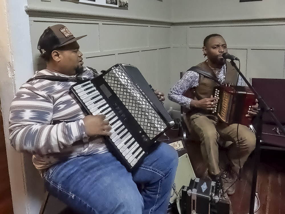 two men playing the accordion and singing on Creole French