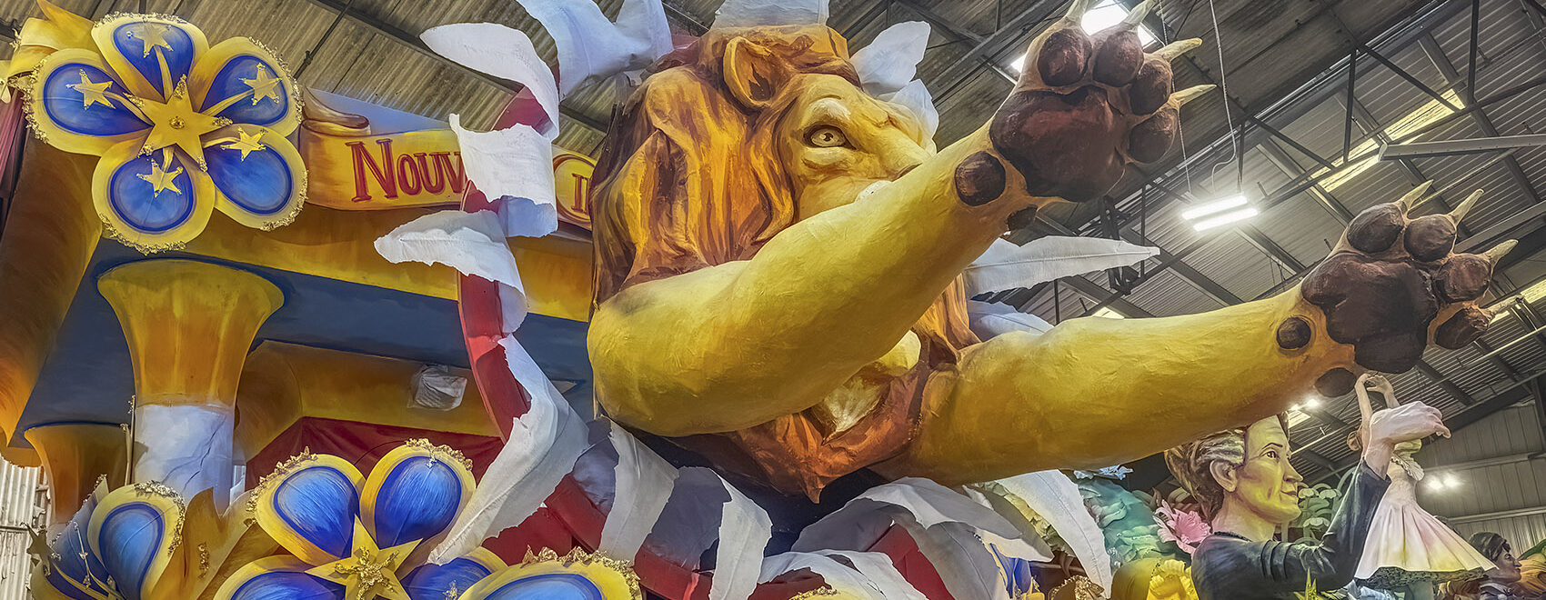 colorful mardi gras float with lion and blue and yellow flowers