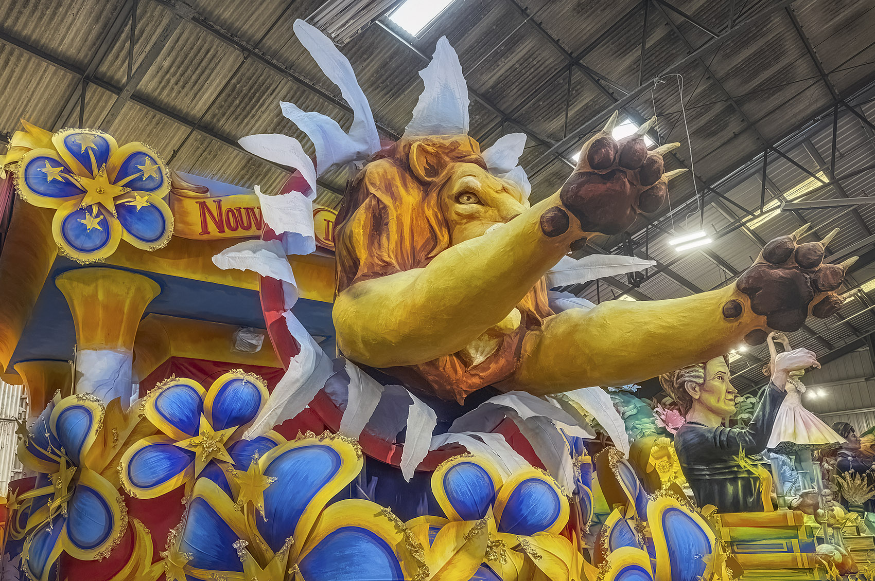 colorful mardi gras float with lion and blue and yellow flowers