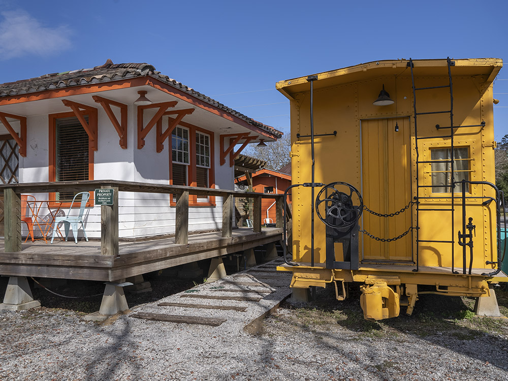 yellow caboose next to old train ticket office