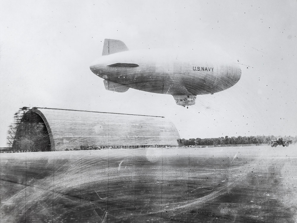 black and white photograph of navy blimp and hangar and Houma blimp base