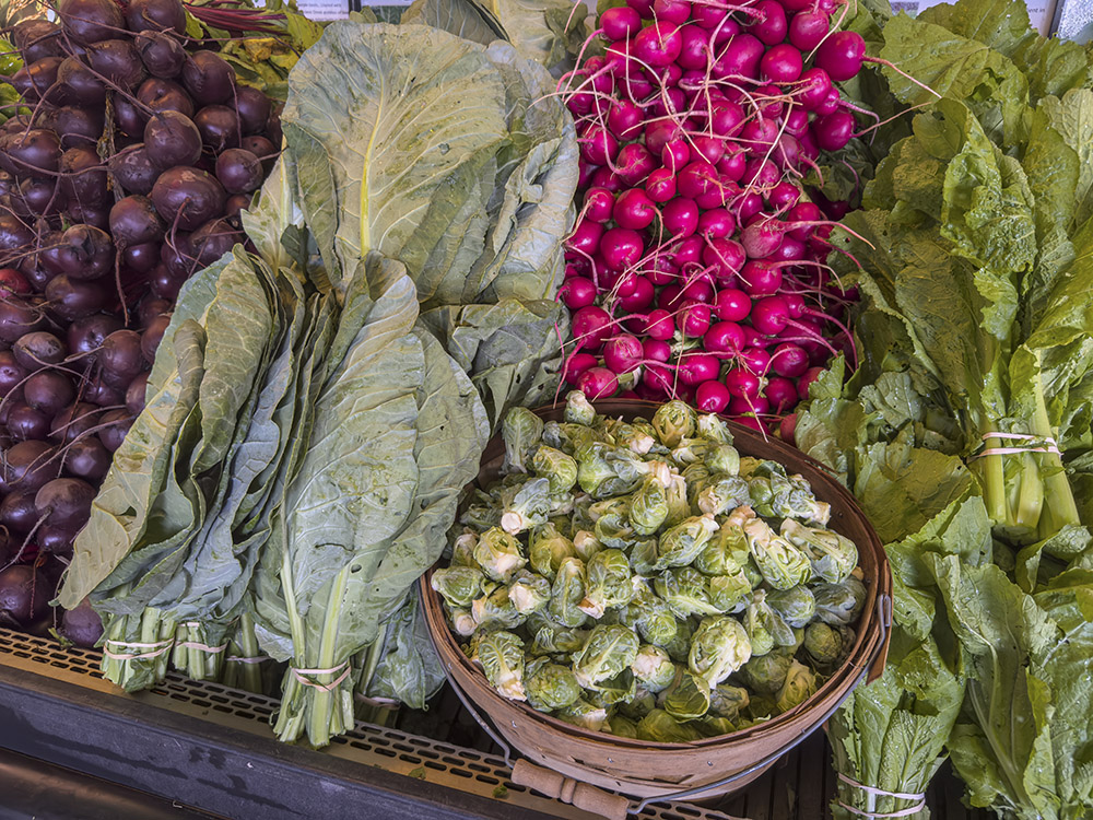 collards raedishes and brussels sprouts for sale in farmers market