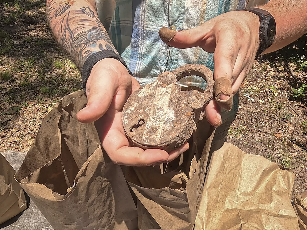 man's hands holding old rustyi padlock