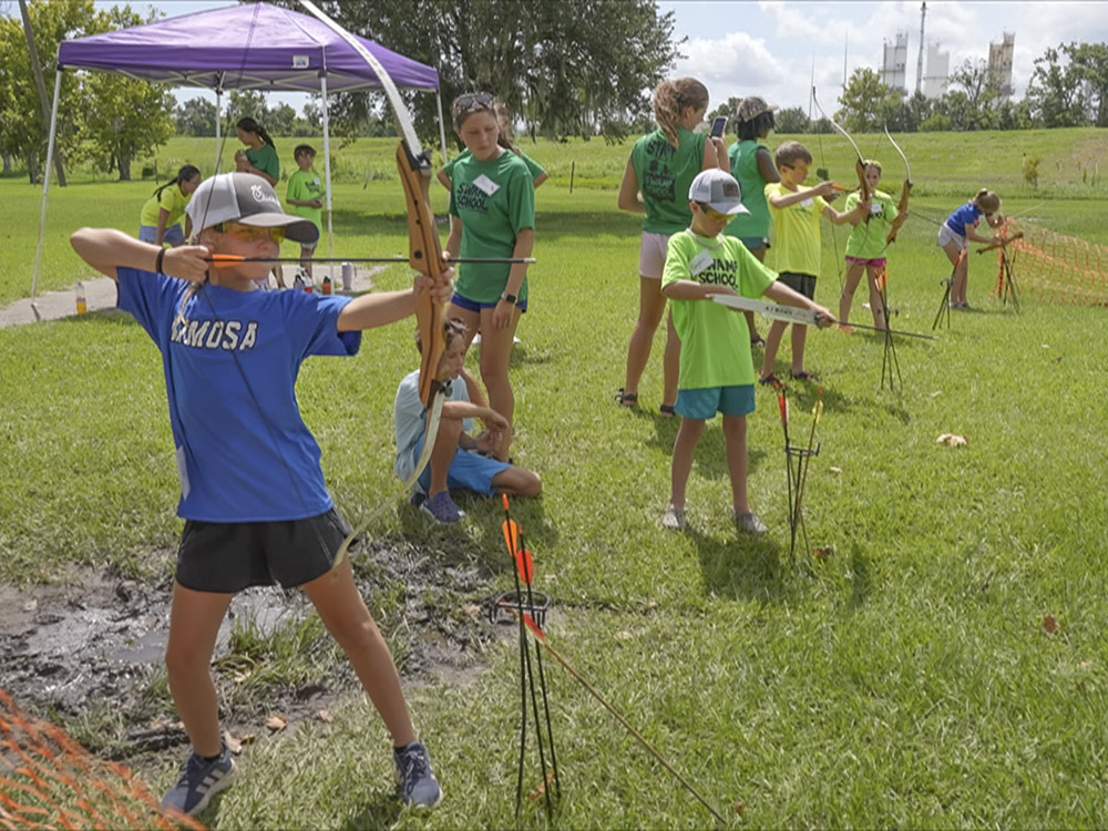children on archery range shooting bow and arrow