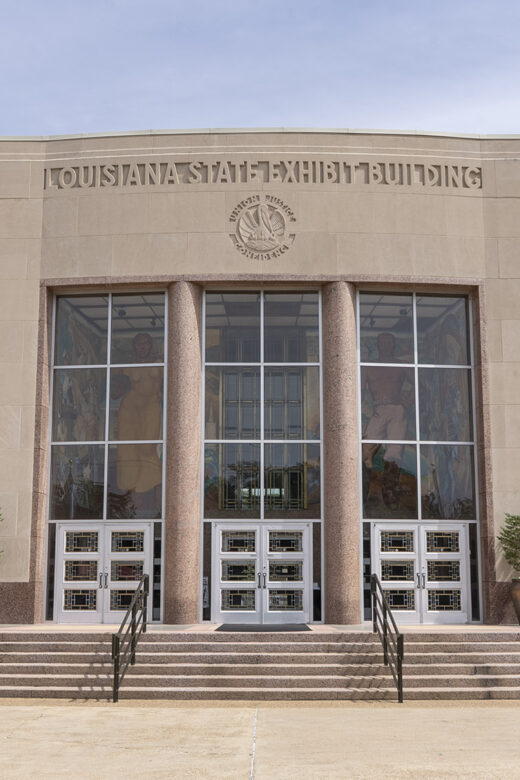 large granite building with large windows and columns and name State Exhibit Museum