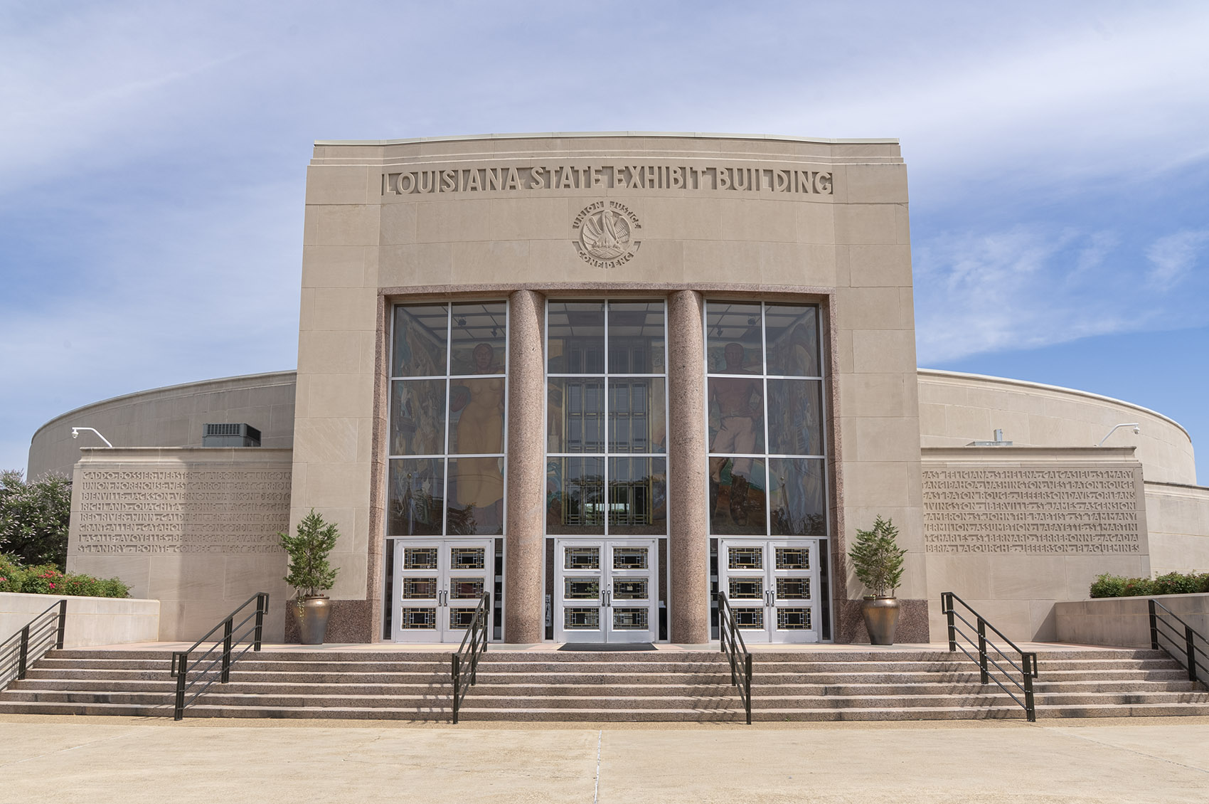 large granite building with large windows and columns and name State Exhibit Museum