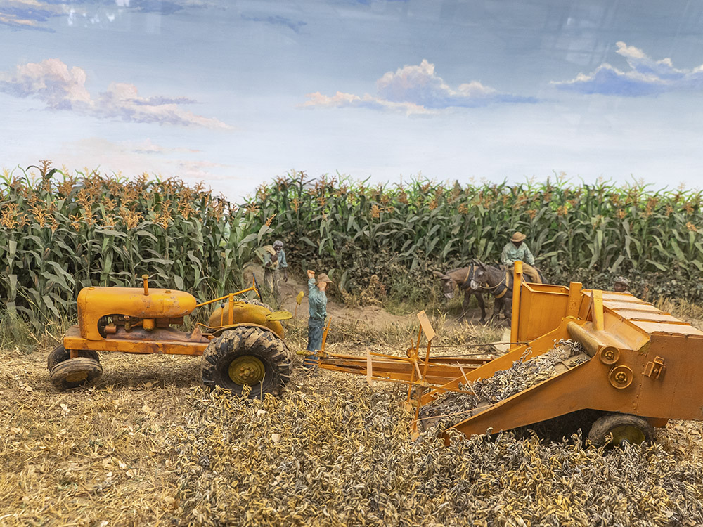 diorama of corn farm with yellow tractor and farm machine