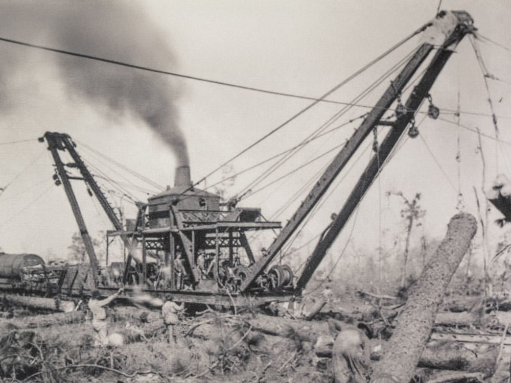 black and white photo of lumber skidder with cranes hauling cut timber