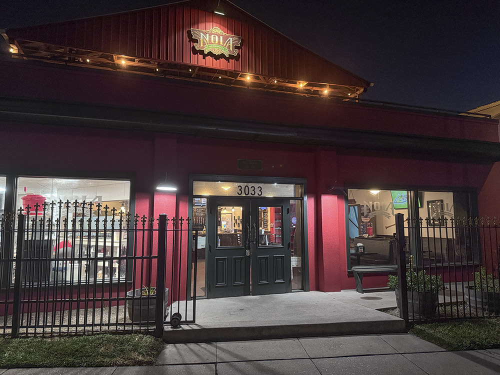 red building at night with lights for New Orleans Brewing