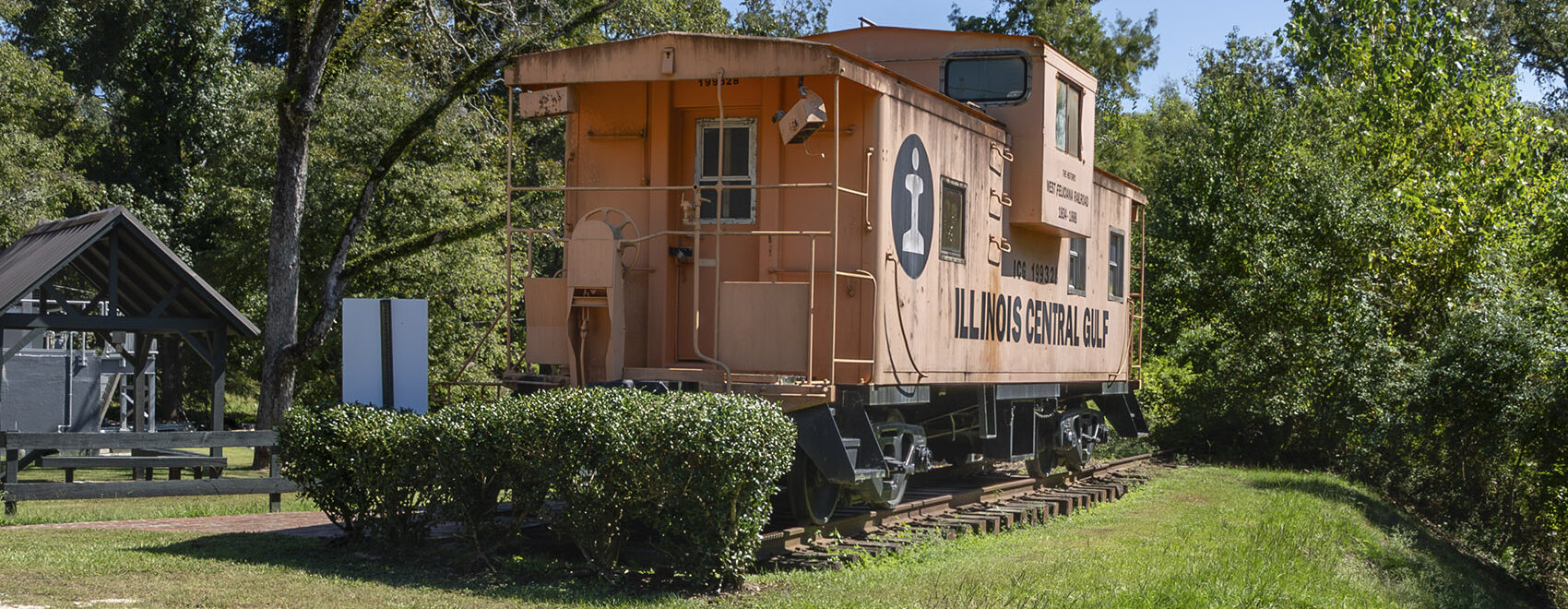 orange Illinois Central Caboose on display in park