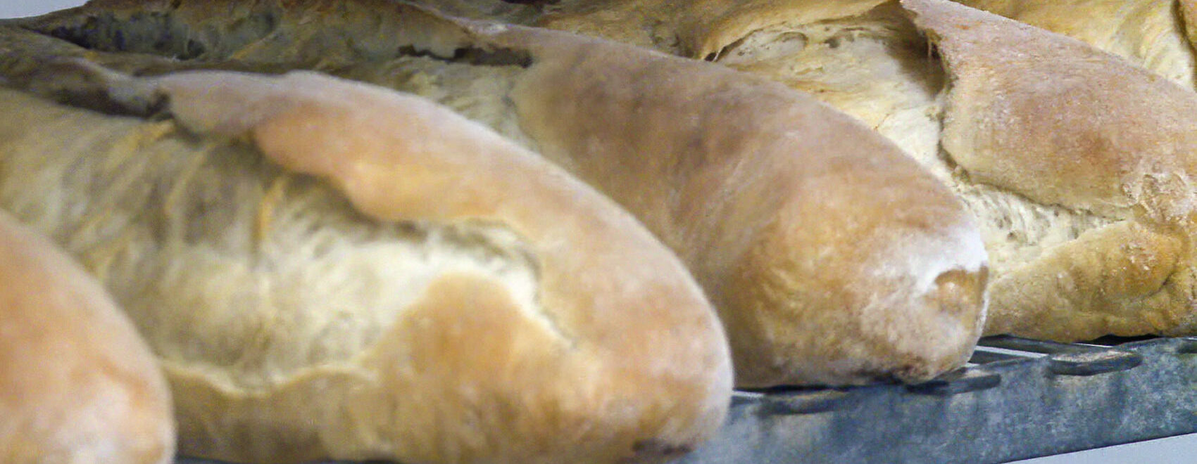 loaves of backed french bread on a shelf