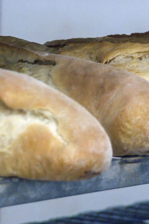 loaves of backed french bread on a shelf