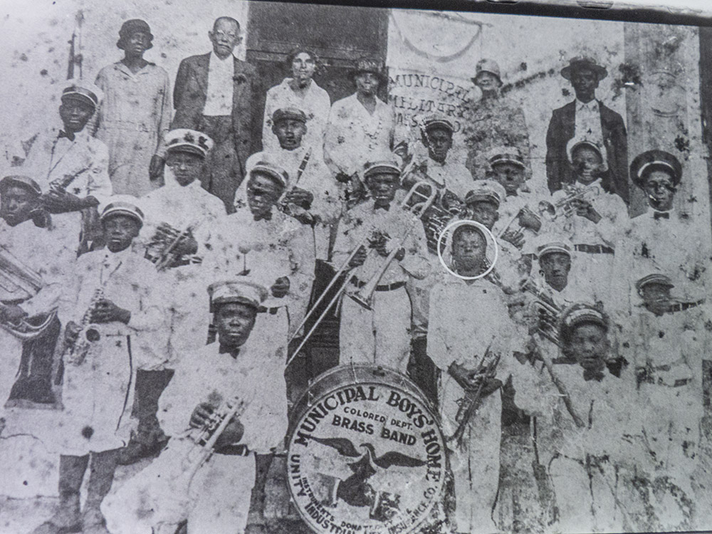 black and white photograph of young Louis Armstrong and other child musicians in white uniforms