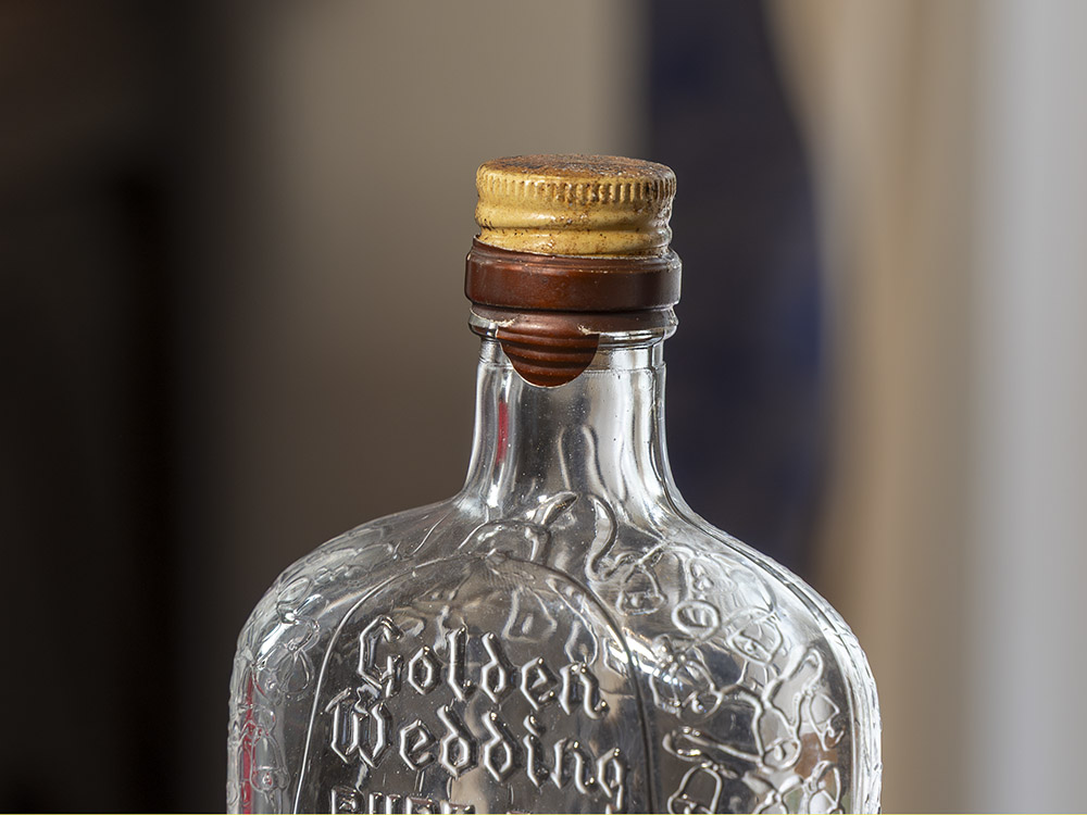 sealed cap of whiskey bottle with Golden Wedding printed in the glass