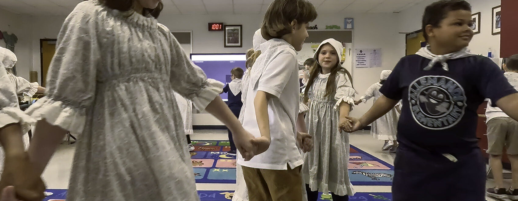 young students holding hands and dancing in traditional Cajun dress
