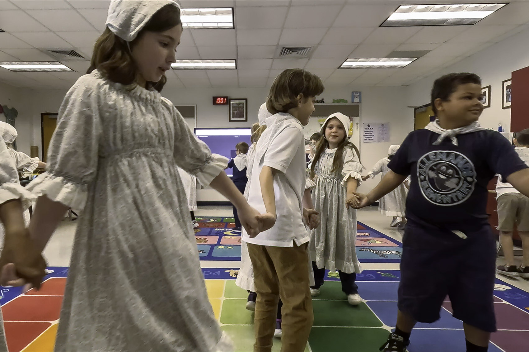 young students holding hands and dancing in traditional Cajun dress