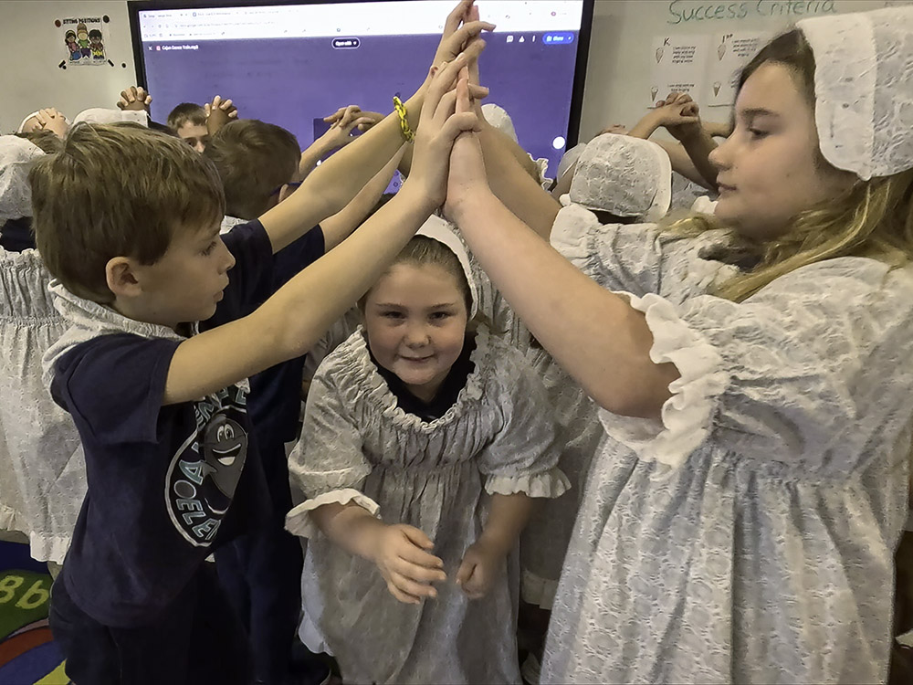 children in traditional costumes dancing in classroom