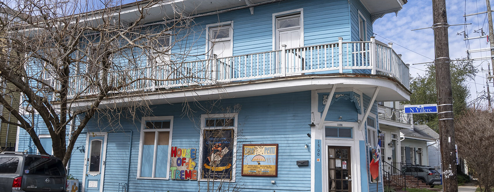 2 story blue wooden building with balcony and sign for Treme Jazz museum
