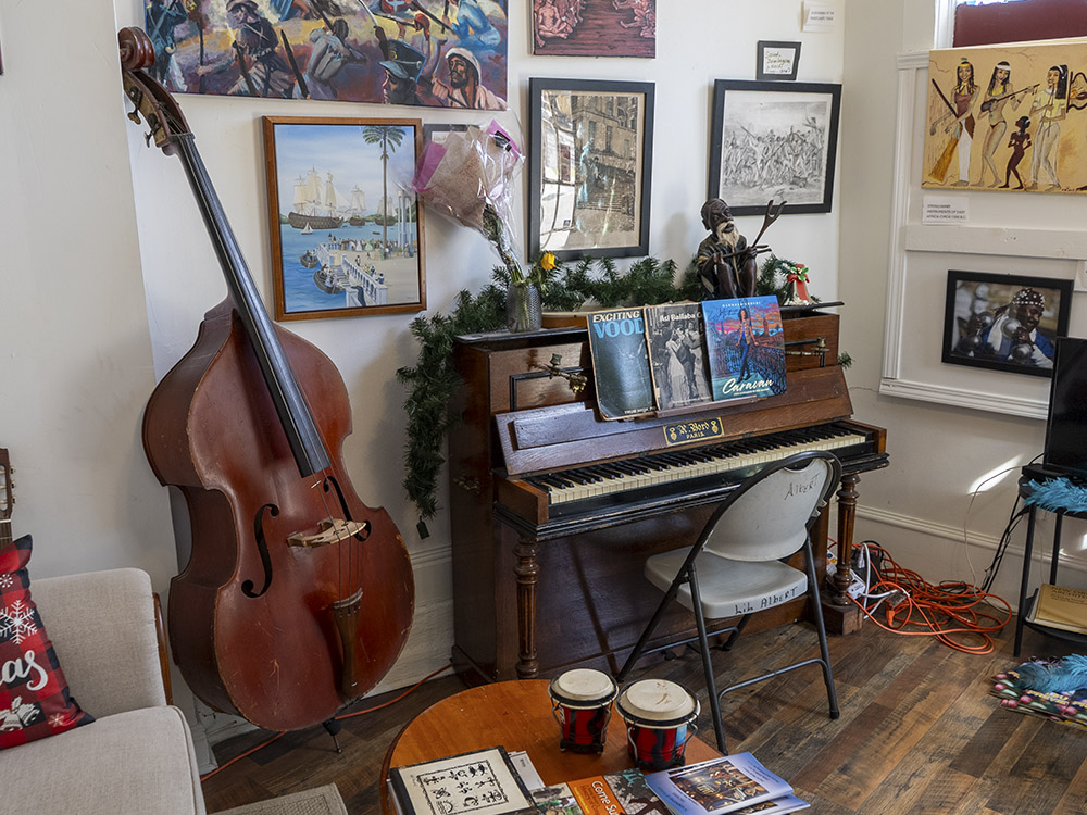 upright bass, piano, bongo drums and pictures hanging on wall of museum