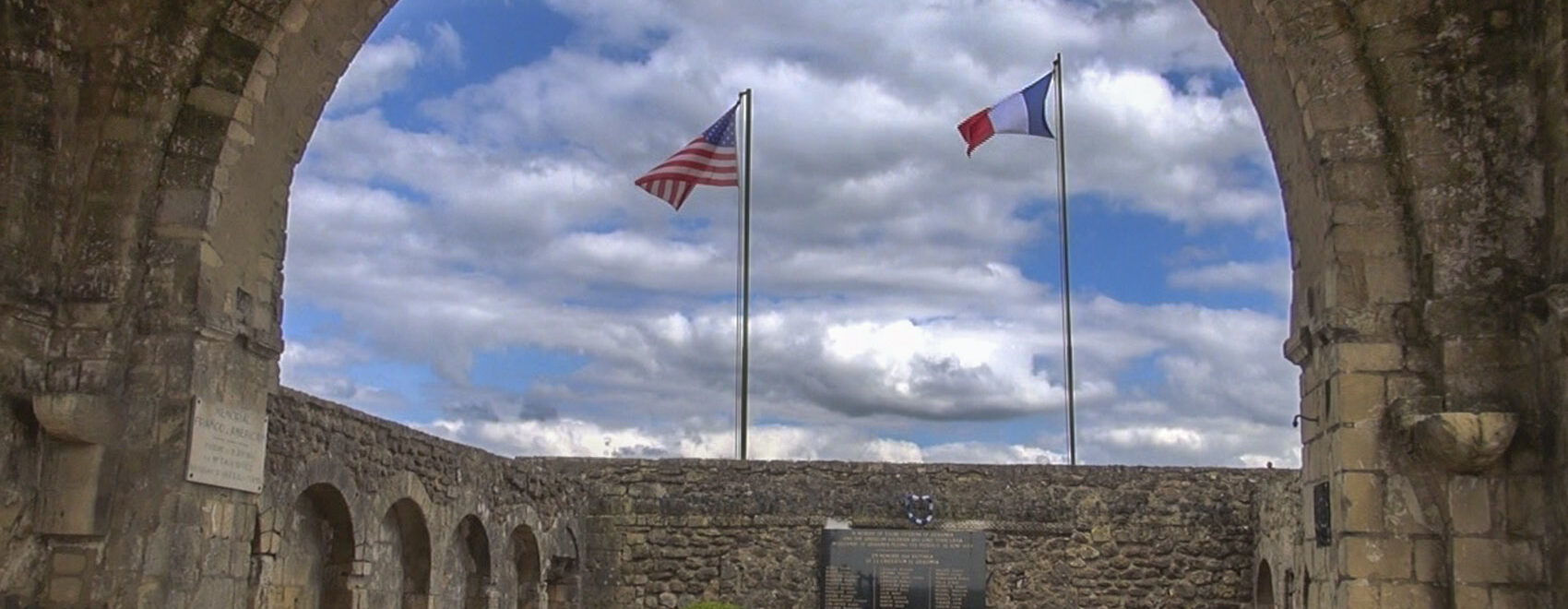 american and french flags above a world war 2 memorial